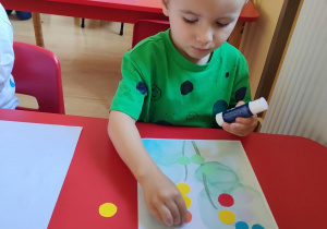 Oluś wykonuje pracę plastyczną