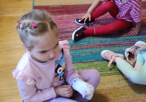 Maja ćwiczy samodzielne zakładanie skarpetek, Łucja samodzielnie zakłada buty