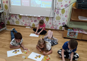 Dzieci układają jesienne puzzle.