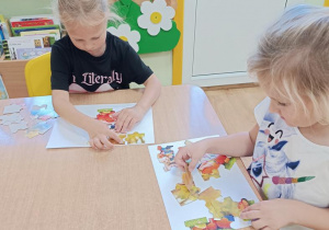 Dzieci układają jesienne puzzle.
