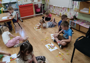 Dzieci układają jesienne puzzle.