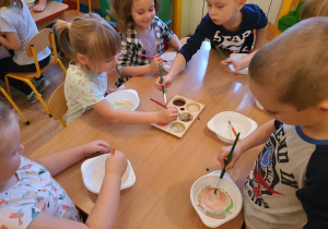 Dzieci malują obrazy na mleku z wykorzystaniem farb plakatowych,