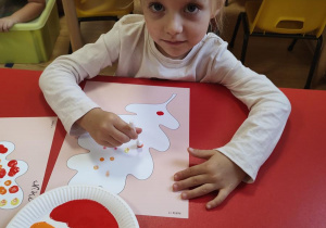 Marysia wypełnia kontur liścia farbą