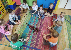 Dzieci przeliczają kasztany używając stóp