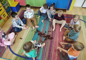 Dzieci przeliczają kasztany używając stóp