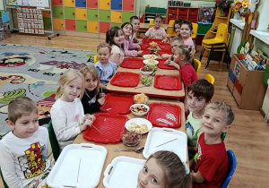 dzieci przygotowują owocowe szaszłyki