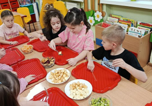 dzieci przygotowują owocowe szaszłyki