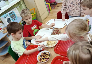 dzieci przygotowują owocowe szaszłyki