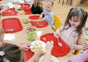 dzieci przygotowują owocowe szaszłyki