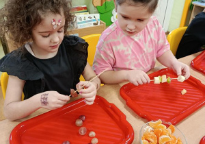 dzieci przygotowują owocowe szaszłyki