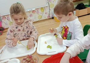 dzieci przygotowują owocowe szaszłyki