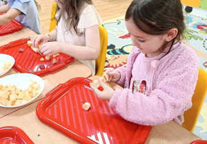 dzieci przygotowują owocowe szaszłyki