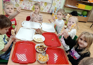 dzieci przygotowują owocowe szaszłyki