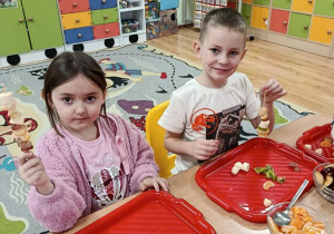 dzieci przygotowują owocowe szaszłyki