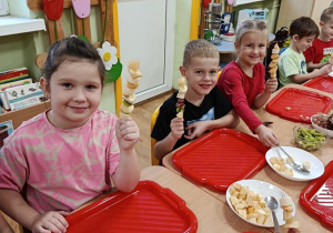 dzieci przygotowują owocowe szaszłyki