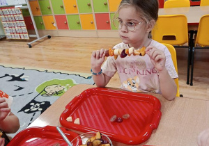 dzieci przygotowują owocowe szaszłyki