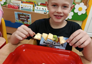 dzieci przygotowują owocowe szaszłyki