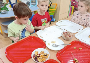 dzieci przygotowują owocowe szaszłyki