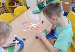 Dzieci sklejają białe i czerwone paski a następnie składają z nich flagę i rysują flamastrami z czym kojarzy się Ojczyzna.