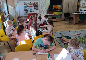 Dzieci kolorują emblematy "Jestem Polką", "Jestem Polakiem".