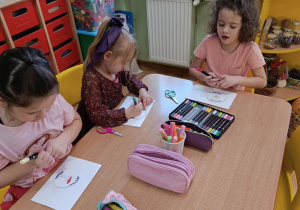 Dzieci kolorują emblematy "Jestem Polką", "Jestem Polakiem"