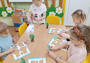 Dzieci wypychają elementy a następnie składają drzewo, rycerza na koniu, orła i gniazdo.