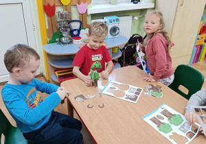 Dzieci wypychają elementy a następnie składają drzewo, rycerza na koniu, orła i gniazdo.