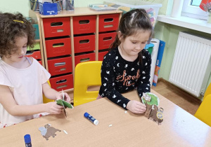 Dzieci wypychają elementy a następnie składają drzewo, rycerza na koniu, orła i gniazdo.