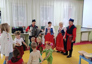 Zabawy taneczne dzieci podczas występu zespołu ludowego.