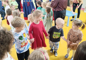 Zabawy taneczne dzieci podczas występu zespołu ludowego.