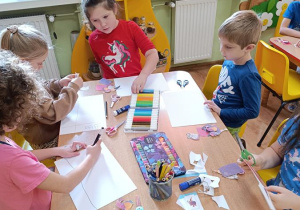 Dzieci wycinają, składają i sklejają lajkonika.