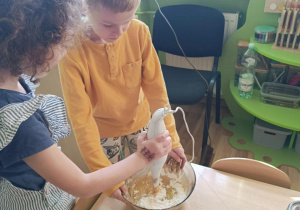 Dzieci przygotowują ciasto dyniowe.