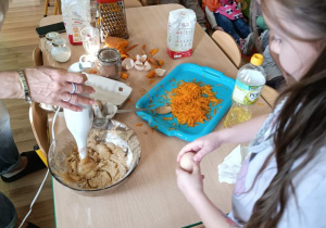 Dzieci przygotowują ciasto dyniowe.