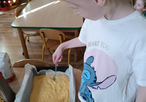 Dzieci przygotowują ciasto dyniowe.