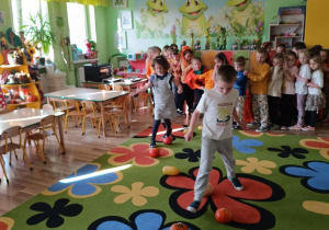 Dzieci pokonują slalom między dyniami.