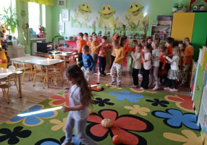 Dzieci pokonują slalom między dyniami.