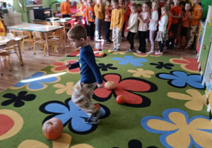 Dzieci pokonują slalom między dyniami.