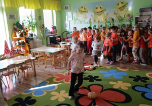 Dzieci pokonują slalom między dyniami.