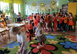 Dzieci pokonują slalom między dyniami.