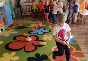 Dzieci pokonują slalom między dyniami.