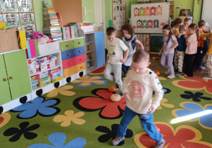 Dzieci pokonują slalom między dyniami.