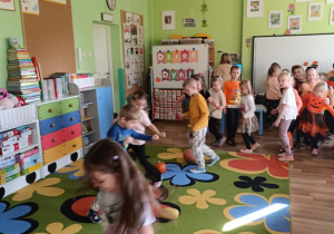 Dzieci pokonują slalom między dyniami.