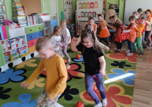 Dzieci pokonują slalom między dyniami.