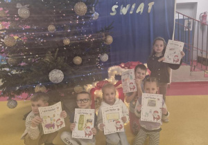 Dzieci z listami do Mikołaja przy choince.