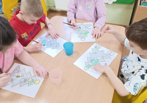 Dzieci malują choinki.