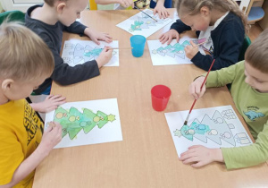 Dzieci malują choinki.