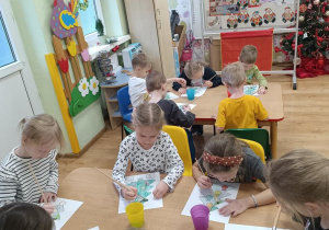 Dzieci malują choinki.