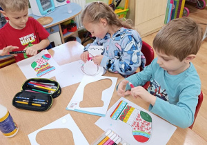 Dzieci ozdabiają skarpety na prezenty.