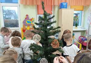 Dzieci ubierają choinkę.