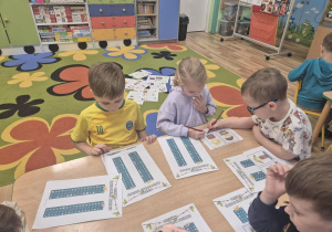 Dzieci wyszukują nazwy zakodowanych prezentów.